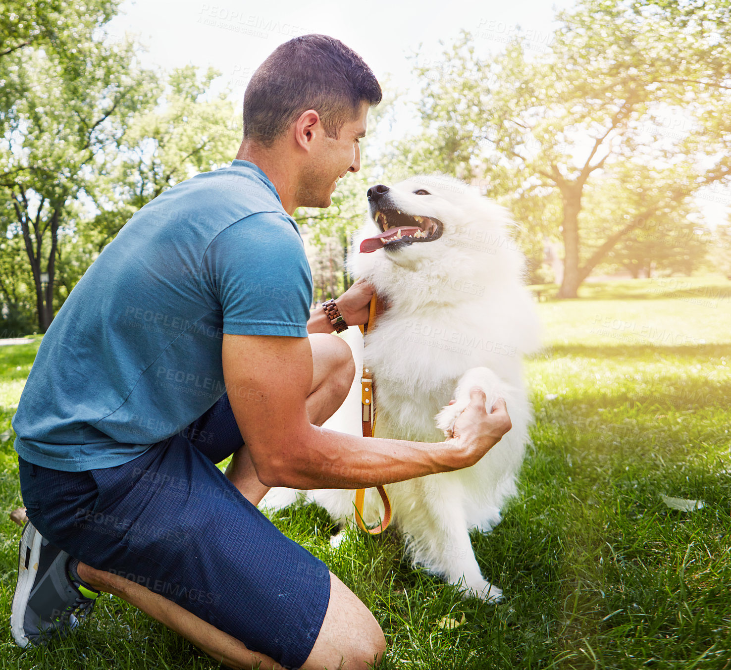 Buy stock photo Shot of a handsome young man walking his dog in the park