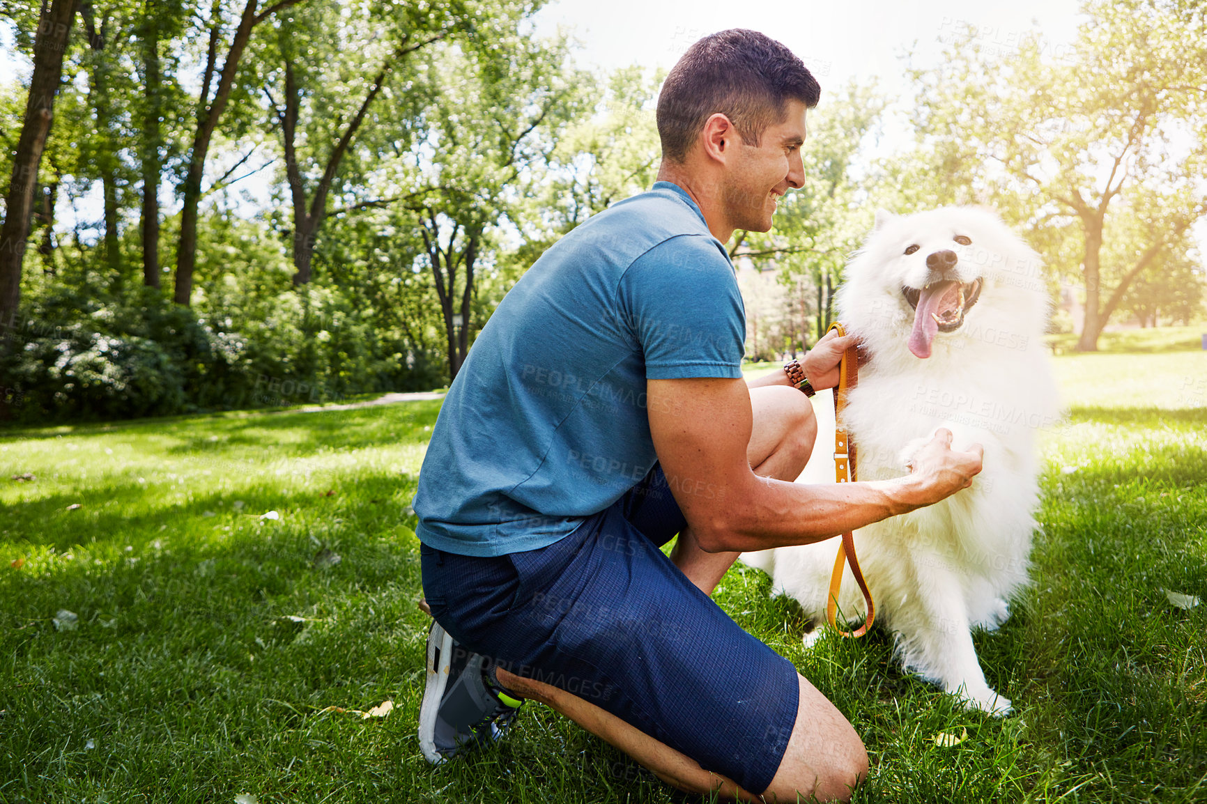 Buy stock photo Shot of a handsome young man walking his dog in the park