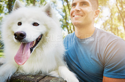 Buy stock photo Shot of a handsome young man walking his dog in the park