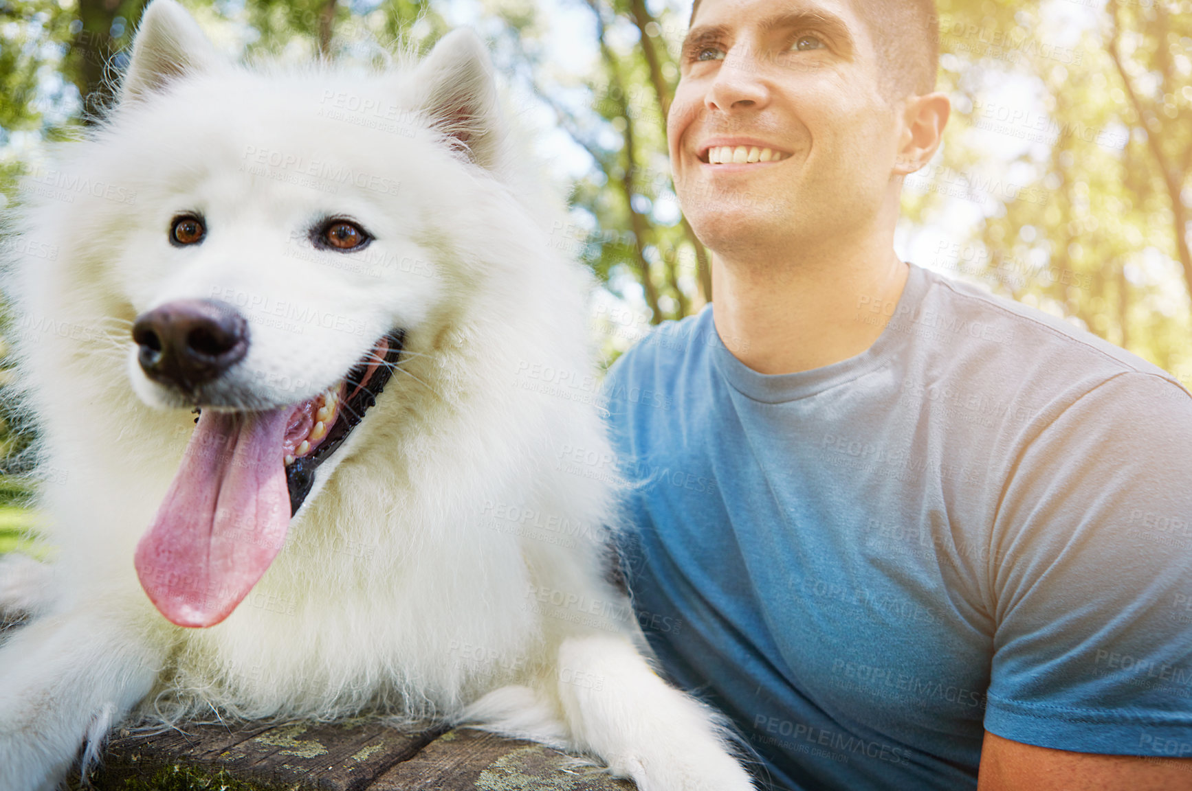 Buy stock photo Shot of a handsome young man walking his dog in the park