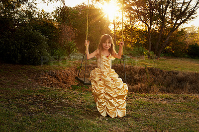 Buy stock photo Portrait of a little girl dressed up as a princess sitting on a swing outside