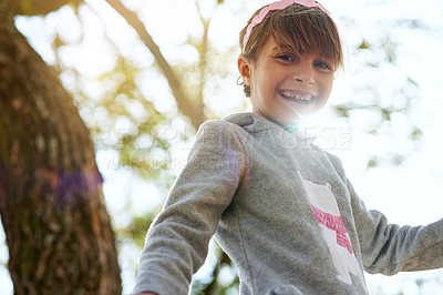 Buy stock photo Portrait of a little girl sitting in a tree in a park