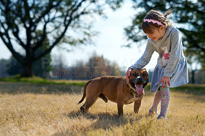 Buy stock photo Shot of a little girl playing with her dog in a park