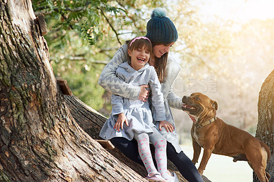 Buy stock photo Cropped shot of a mother and daughter playing with their dog at the park