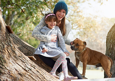 Buy stock photo Portrait of a mother and daughter playing with their dog at the park