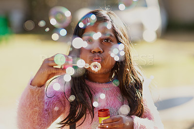 Buy stock photo Cropped shot of a little girl blowing bubbles outside