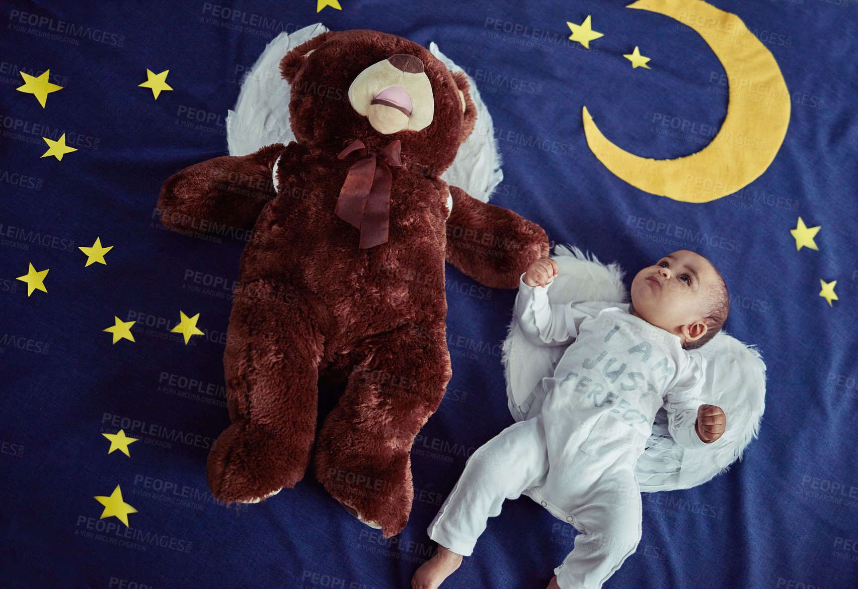 Buy stock photo Concept shot of an adorable baby boy and a teddy bear wearing angel wings against an imaginary night time background