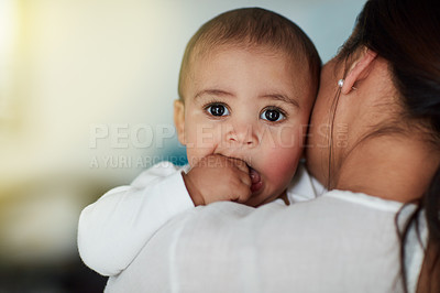 Buy stock photo Shot of a loving mother carrying her baby boy at home