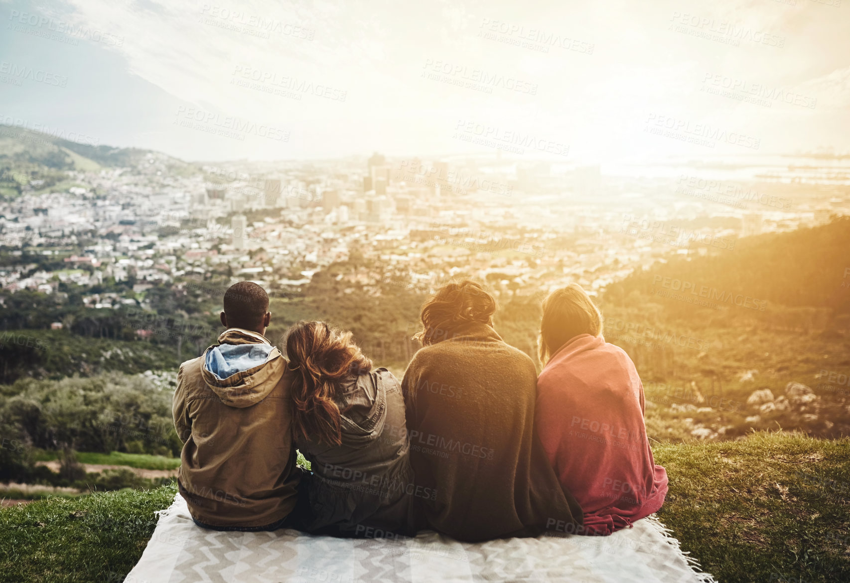 Buy stock photo Rearview shot of a group of friends admiring a view while sitting outside together