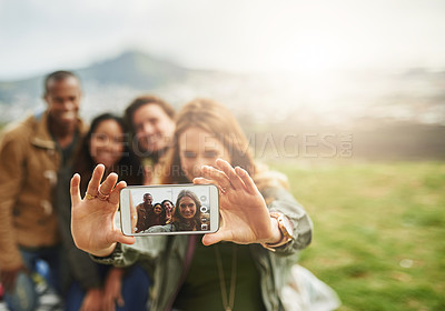 Buy stock photo Shot of a group of friends taking a selfie while standing outside