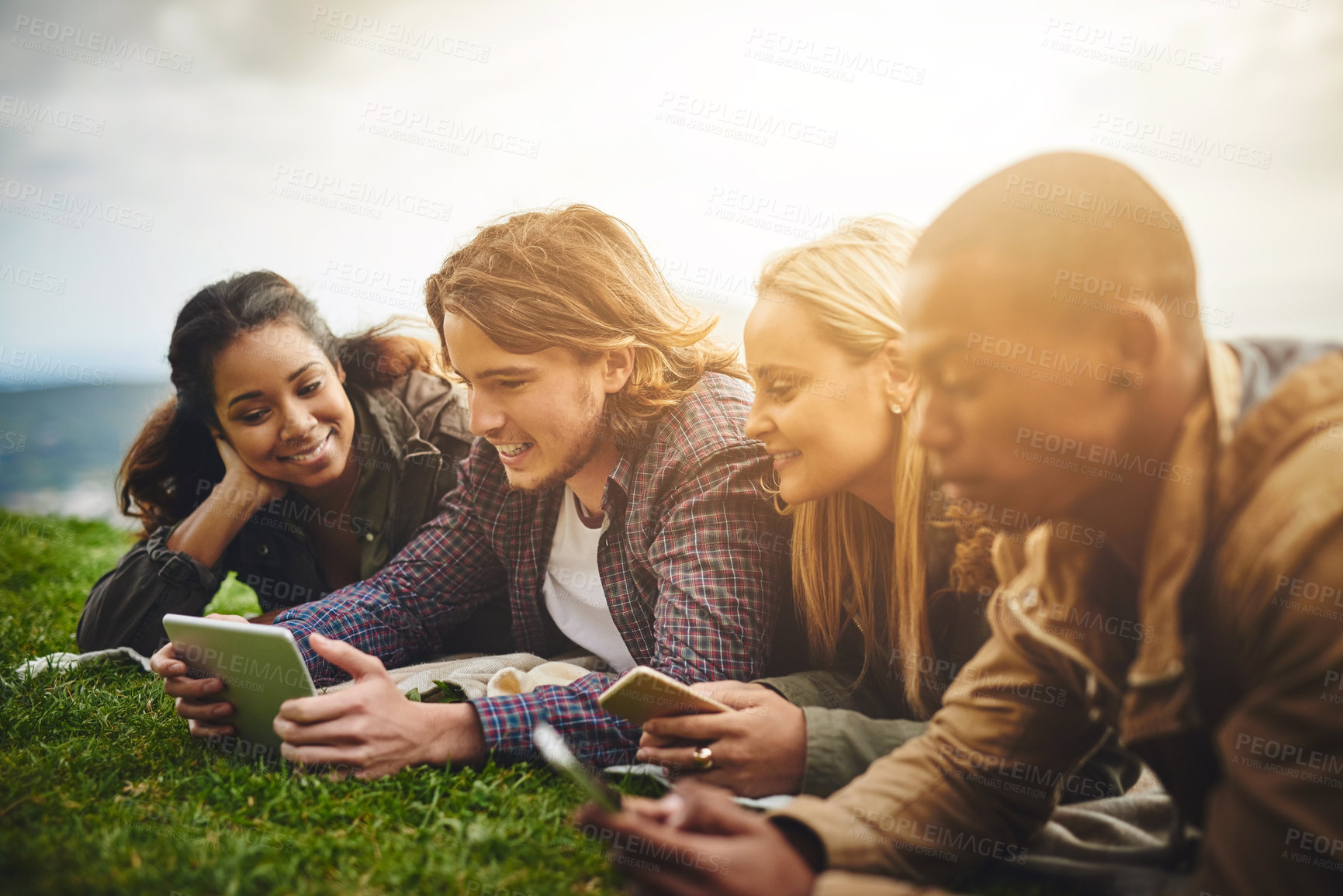 Buy stock photo Happy, students and friends in park on tablet for online learning, social media and internet outdoors. Diversity, relax and men and women on digital tech for education, studying and college in nature