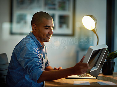 Buy stock photo Cropped shot of a young businessman looking at a photo frame while working late at his office desk