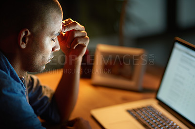 Buy stock photo Cropped shot of a young businessman looking stressed out while working late in an office