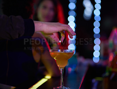 Buy stock photo Closeup shot of a man dropping a pill into a  woman's cocktail in a nightclub
