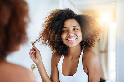 Buy stock photo Shot of an attractive young woman going through her morning haircare routine