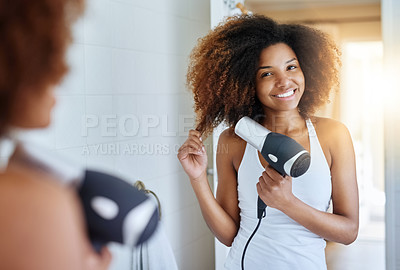Buy stock photo Portrait of an attractive young woman drying her hair with a hairdryer at home
