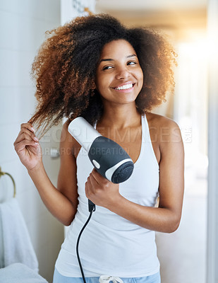 Buy stock photo Shot of an attractive young woman drying her hair with a hairdryer at home
