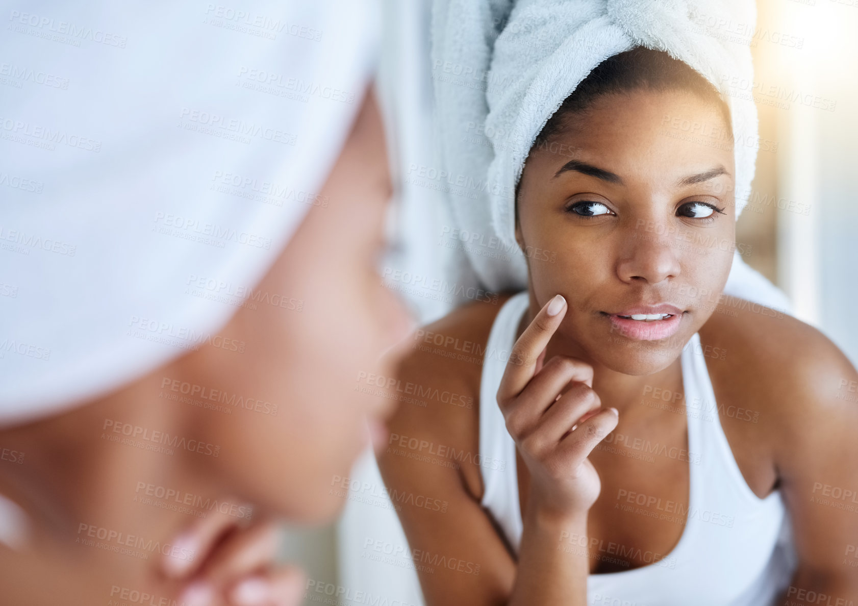 Buy stock photo Shot of a young woman inspecting her skin in front of the bathroom mirror