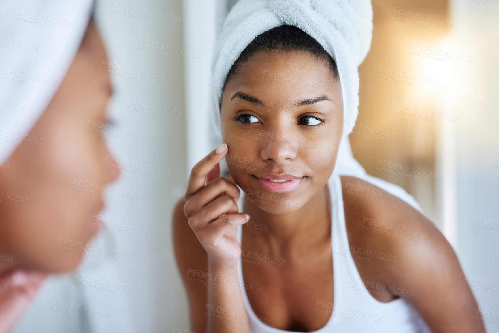 Buy stock photo Shot of a young woman inspecting her skin in front of the bathroom mirror