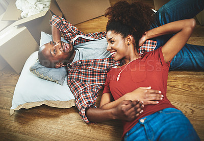 Buy stock photo Relax, moving and happy couple on floor in new home with boxes, talking and mortgage with high angle. Smile, black man and woman in house together with romantic embrace, love and property investment