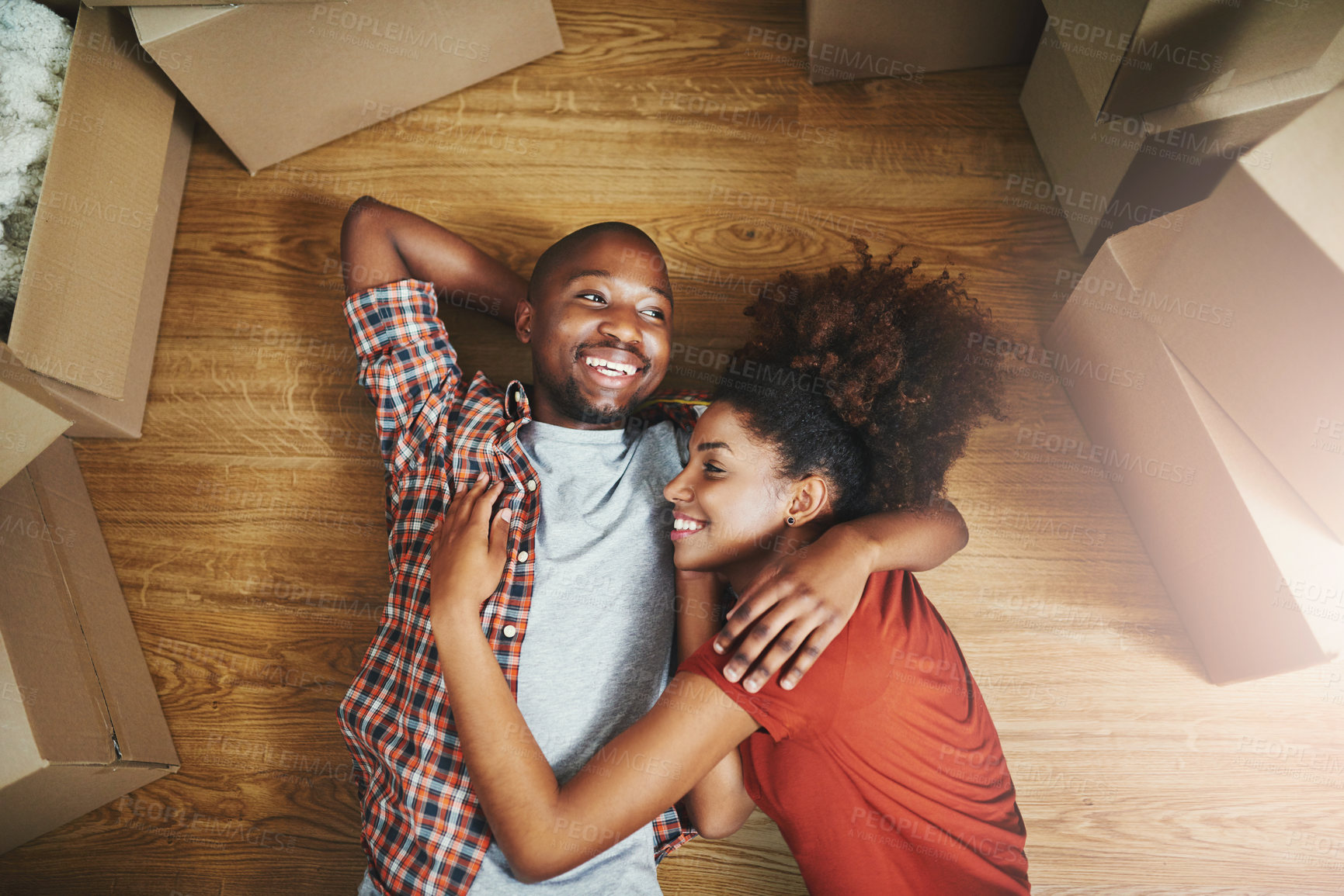 Buy stock photo Relax, embrace and happy couple on floor in new home with boxes, laugh and mortgage with high angle. Smile, black man and woman hug in house together with funny chat, love and property investment.