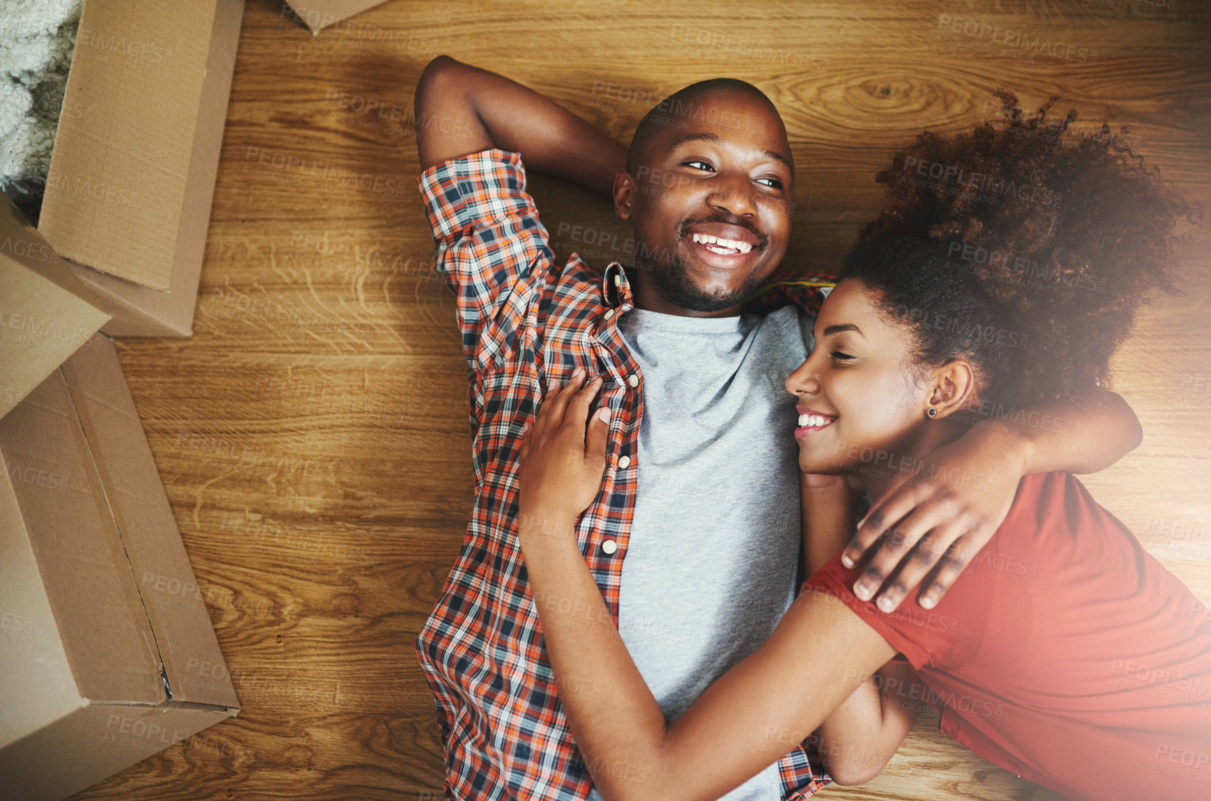 Buy stock photo Relax, hug and happy couple on floor in new home with boxes, laugh and mortgage with high angle. Smile, black man and woman embrace in house together with funny chat, love and property investment.