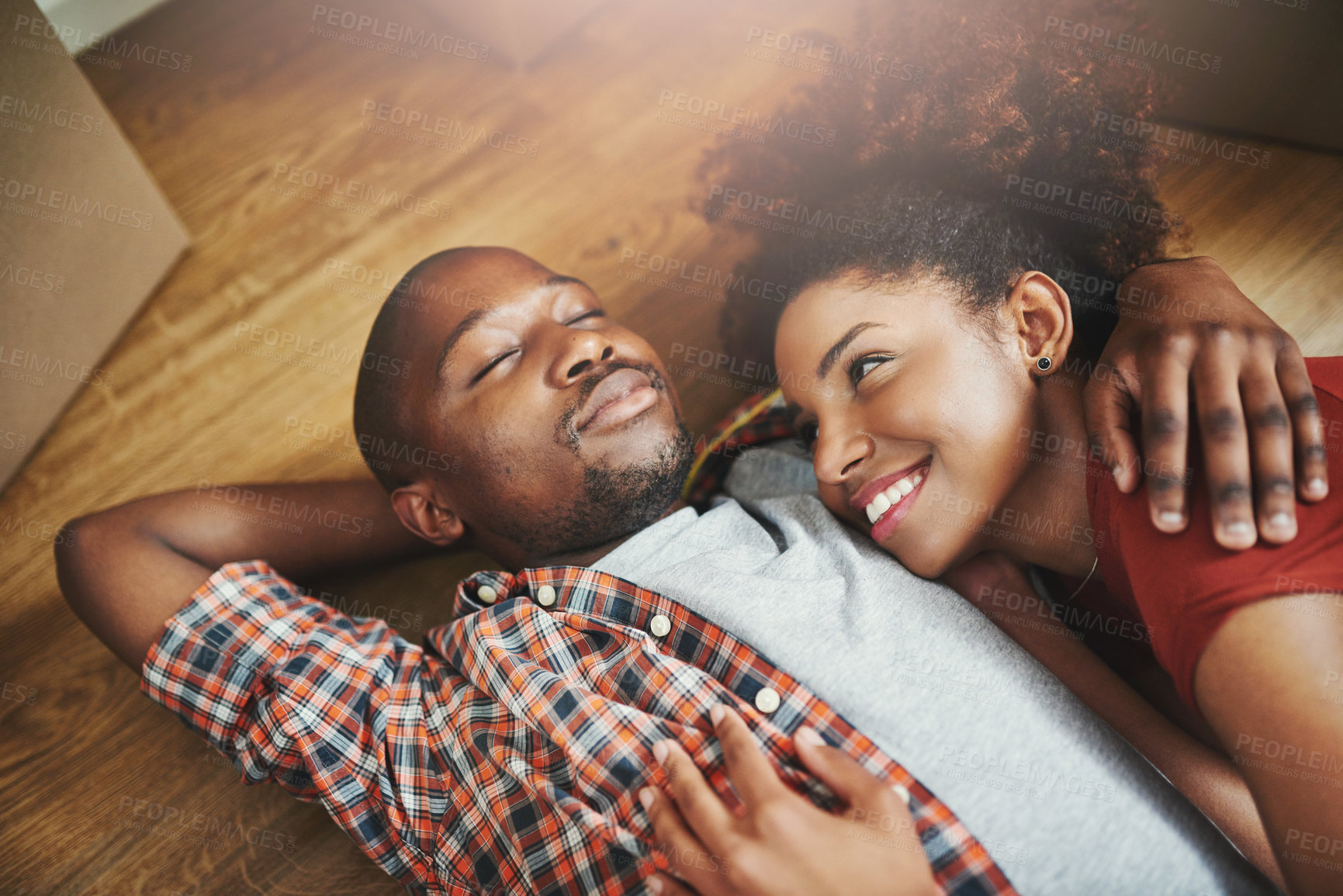 Buy stock photo Sleep, relax and black couple on floor in new home with boxes, tired hug and mortgage with smile. Dream, man and happy woman in house with romantic embrace, love and property investment with fatigue.