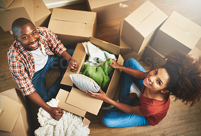 Buy stock photo Portrait of a young couple unpacking boxes while moving into their new home