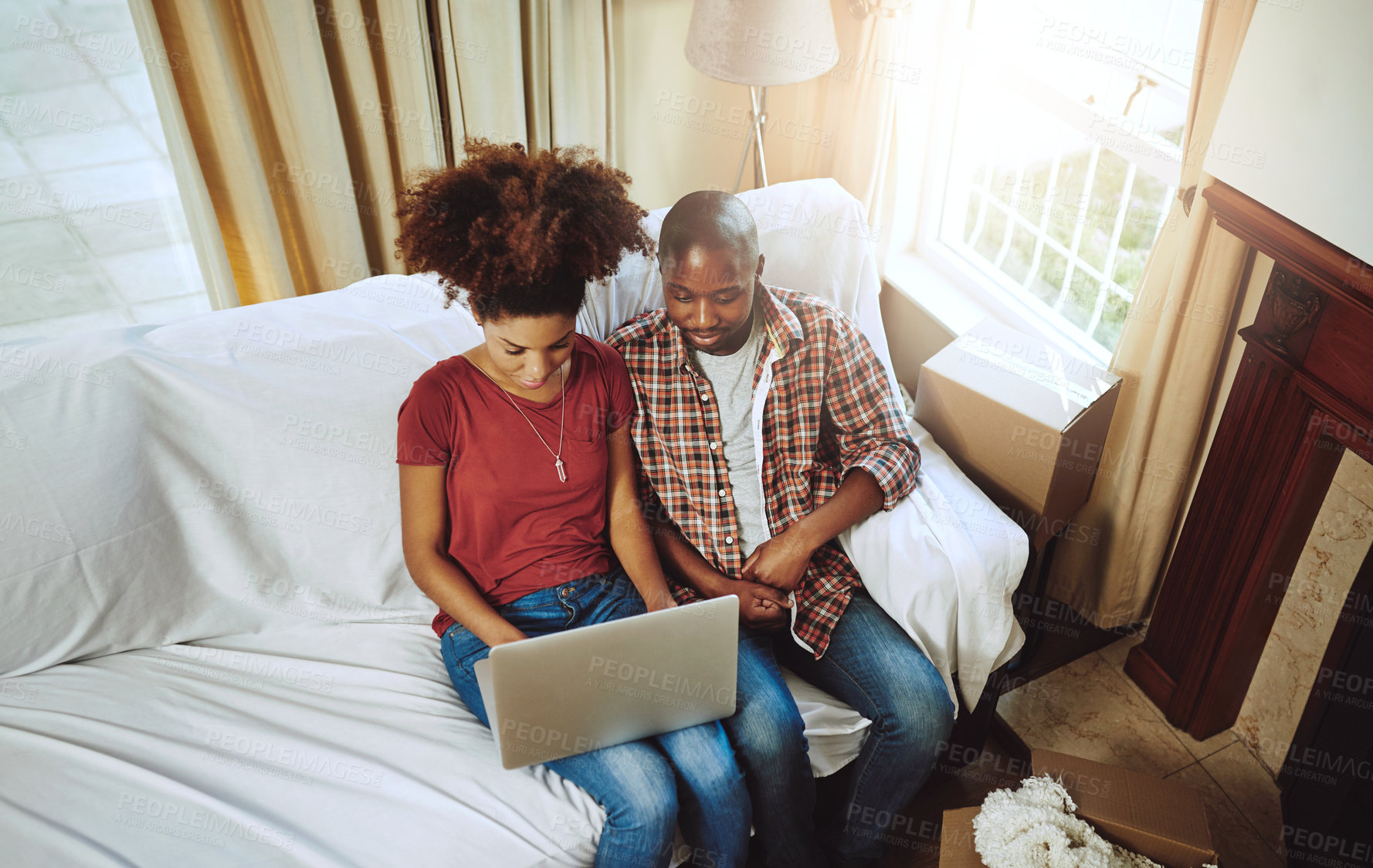Buy stock photo Home, top view and black couple with laptop, couch and connection with internet, relaxing or lens flare. Apartment, sunshine and man with woman, computer or online reading with love, calm or marriage