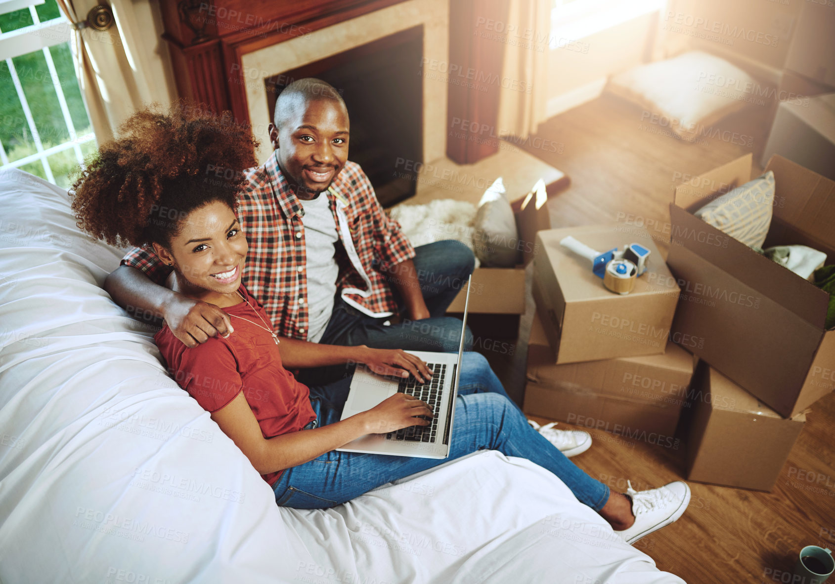 Buy stock photo Portrait of a young couple using a laptop while moving into their new home