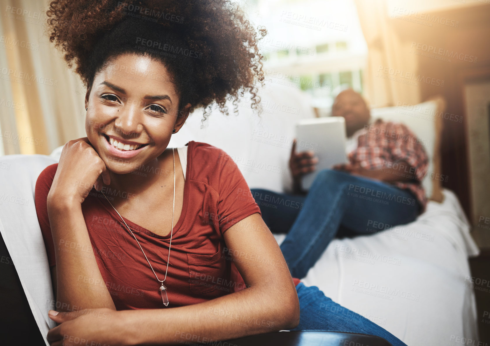 Buy stock photo Portrait of a young woman relaxing at home with her boyfriend in the background