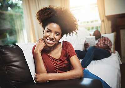 Buy stock photo Portrait of a young woman relaxing at home with her boyfriend in the background