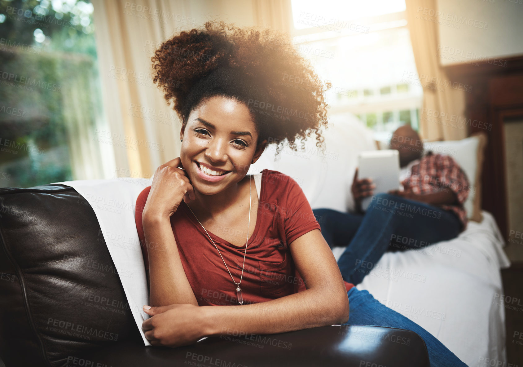 Buy stock photo Portrait of a young woman relaxing at home with her boyfriend in the background