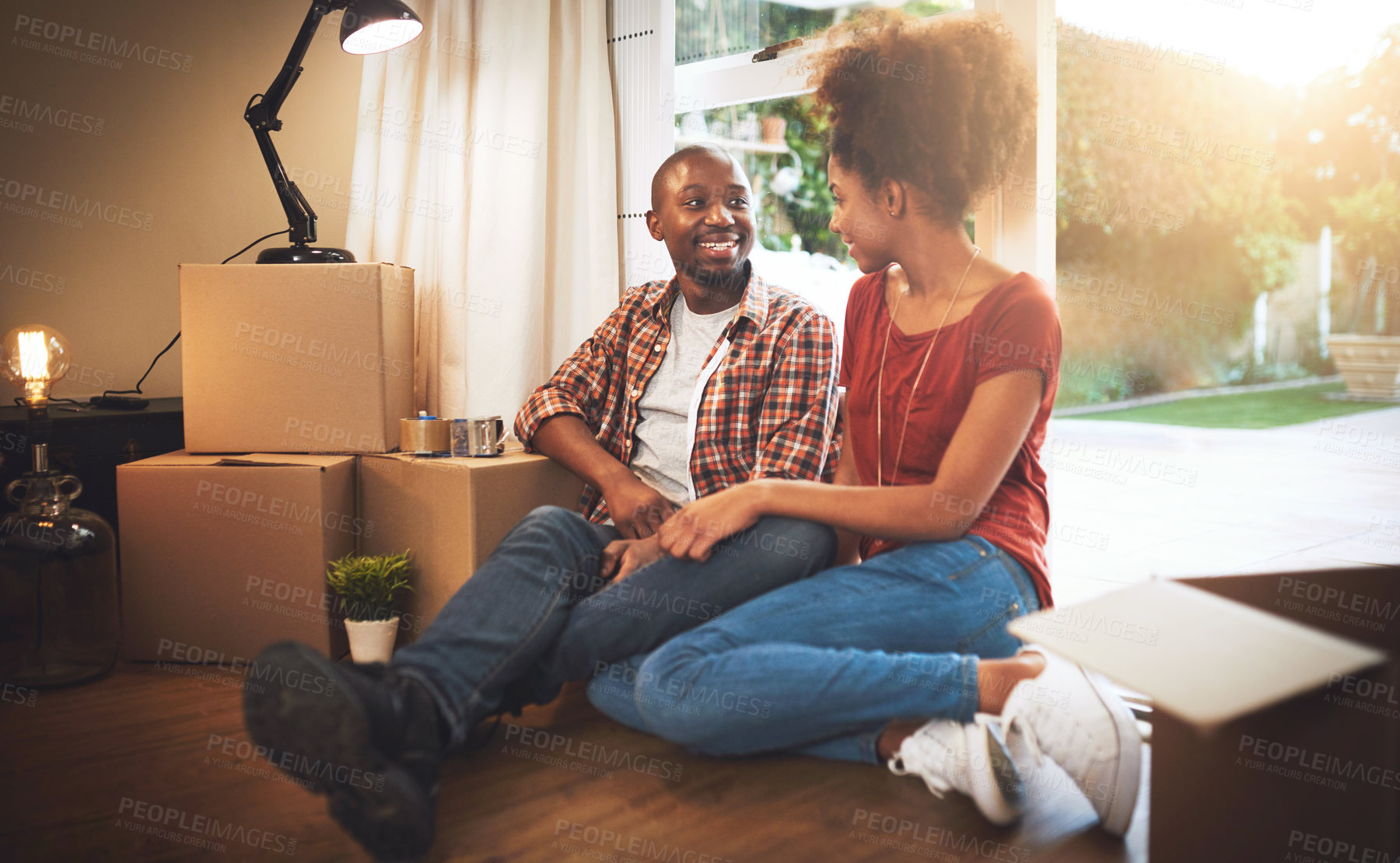 Buy stock photo Shot of a young couple taking a break while moving into their new home