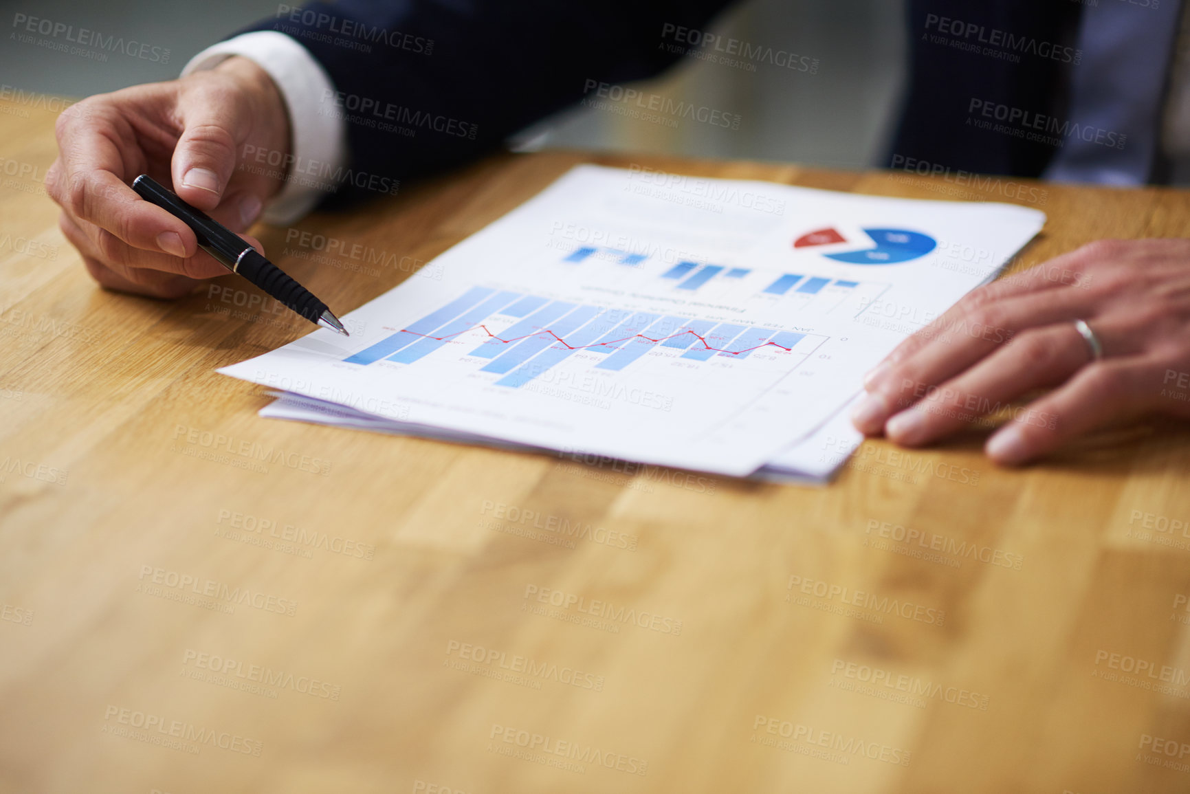 Buy stock photo Closeup shot of a businessman sitting at a table in an office going through graphs