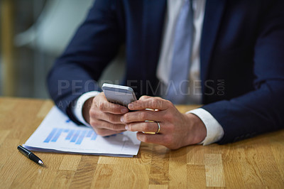 Buy stock photo Closeup shot of a businessman using a cellphone while sitting at a desk in an office