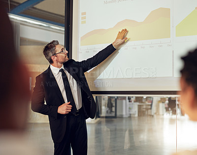 Buy stock photo Shot of an executive giving a presentation on a projection screen to a group of colleagues in a boardroom