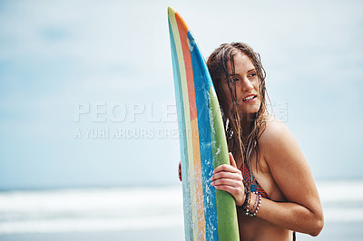 Buy stock photo Shot of an attractive young woman standing on a beach with a surfboard