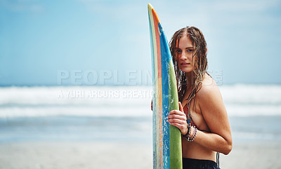 Buy stock photo Portrait of an attractive young woman standing on a beach with a surfboard