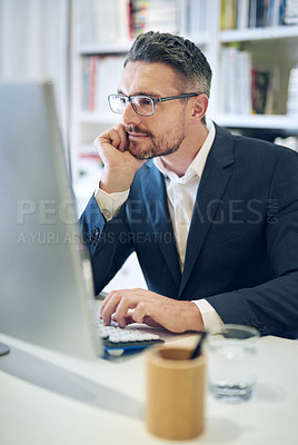 Buy stock photo Shot of a mature businessman working at his computer in an office