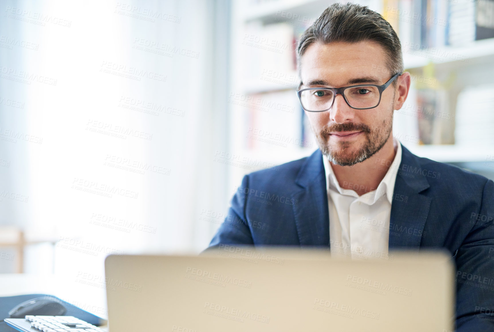 Buy stock photo Shot of a mature businessman working at his computer in an office