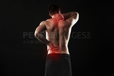 Buy stock photo Studio shot of a sporty young man suffering with  back and neck pain isolated on black