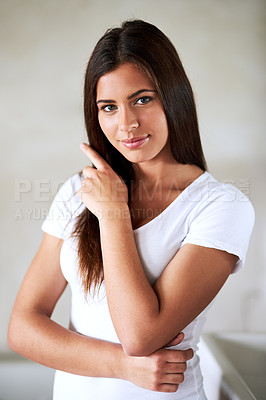 Buy stock photo Portrait of a beautiful young woman stroking her hair at home
