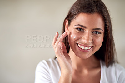 Buy stock photo Portrait of a beautiful woman applying moisturizer to her perfect skin
