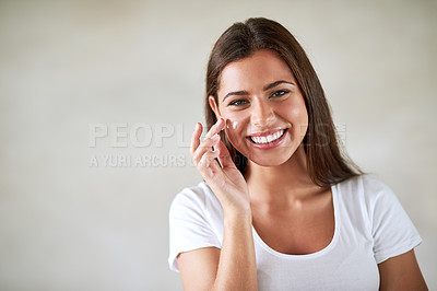 Buy stock photo Portrait of a beautiful woman applying moisturizer to her perfect skin