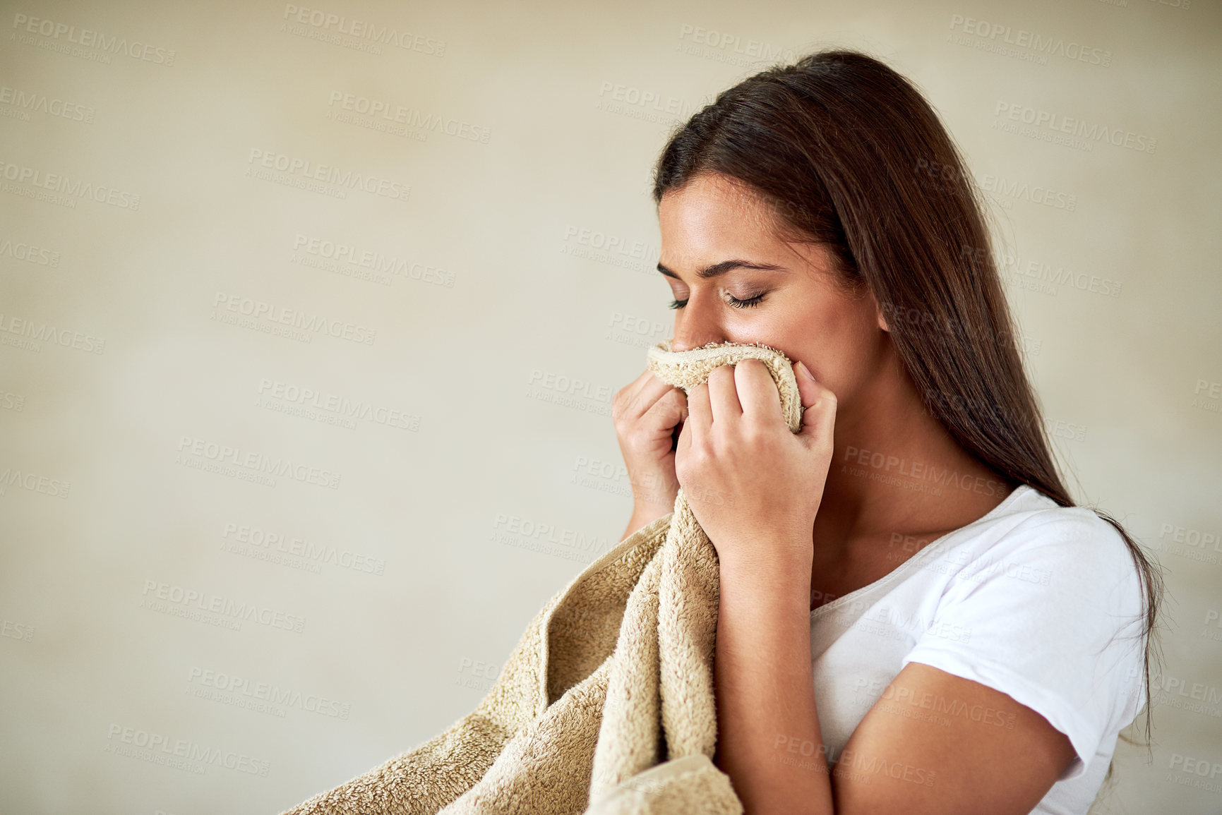 Buy stock photo Shot of young woman enjoying the smell of freshly washed towels