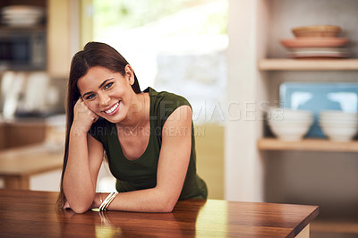 Buy stock photo Portrait of a happy young woman relaxing in her kitchen at home