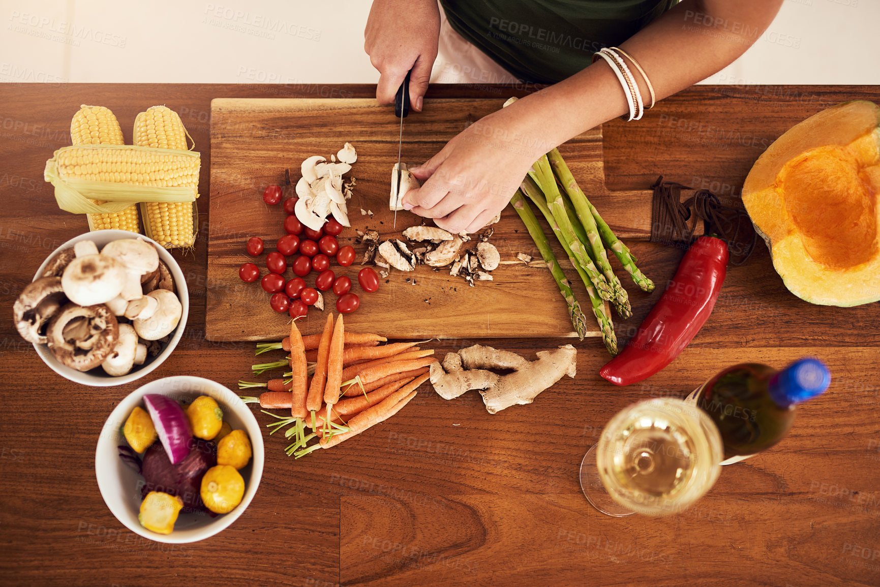 Buy stock photo High angle shot of an unidentifiable woman chopping vegetables in her kitchen