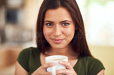 Buy stock photo Portrait of an attractive young woman enjoying a cup of coffee in her kitchen
