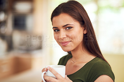 Buy stock photo Portrait of an attractive young woman enjoying a cup of coffee in her kitchen